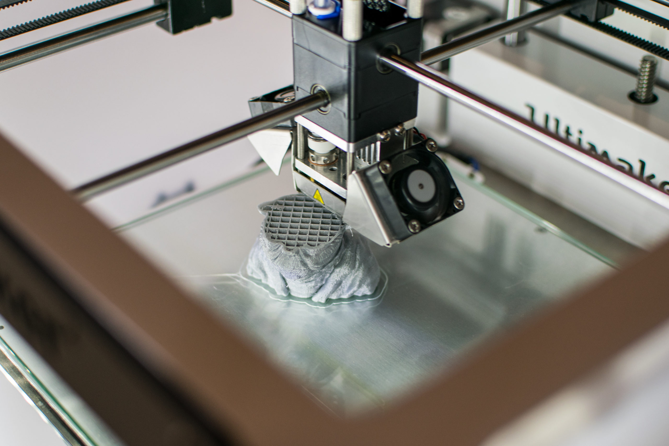 Imprimante 3D en cours d'impression  dans un laboratoire numérique Imprimante 3D en cours d'impression d'un Yoda en résine grise dans un des laboratoires numériques.